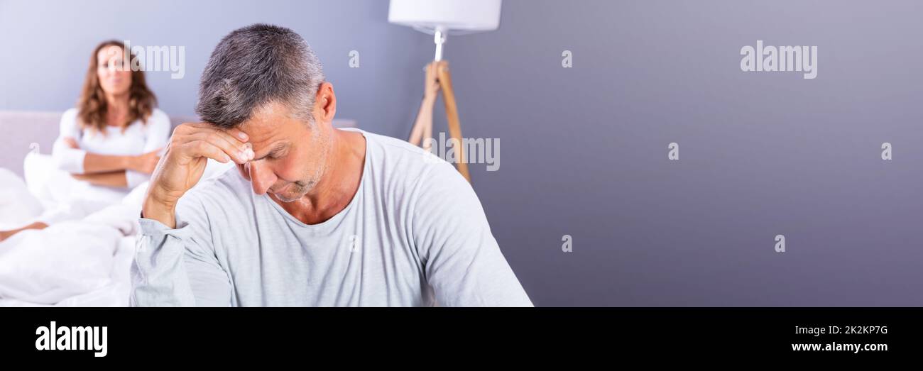 Depressed Man Sitting On Bed Stock Photo