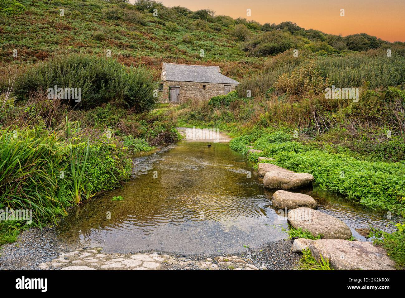 stepping stones across river at Penberth Cove ,at sunset Stock Photo