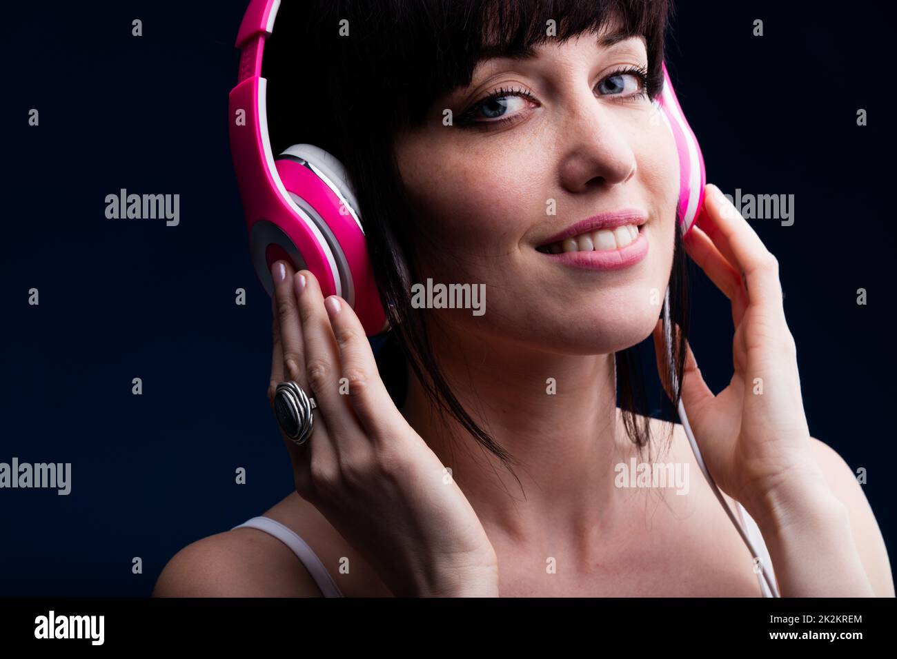 Grinning young adult female using headphones Stock Photo