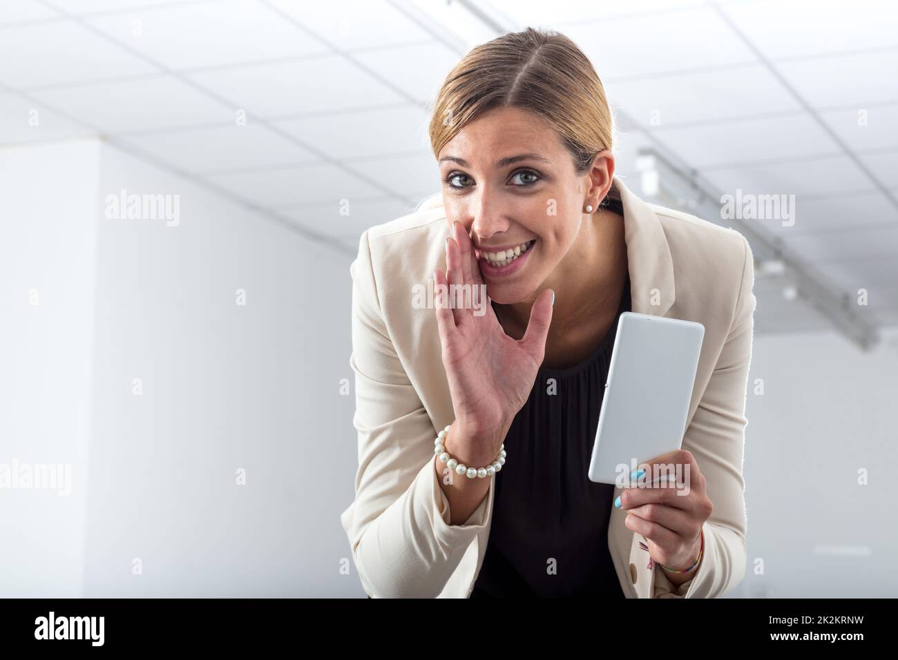 The office gossipmonger whispering her news Stock Photo