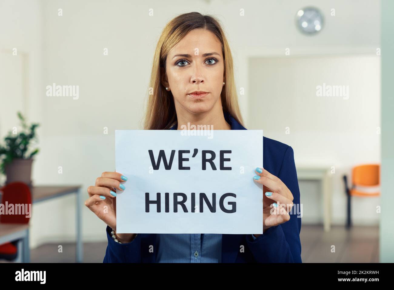 Personnel officer or manageress holding a We're Hiring sign Stock Photo
