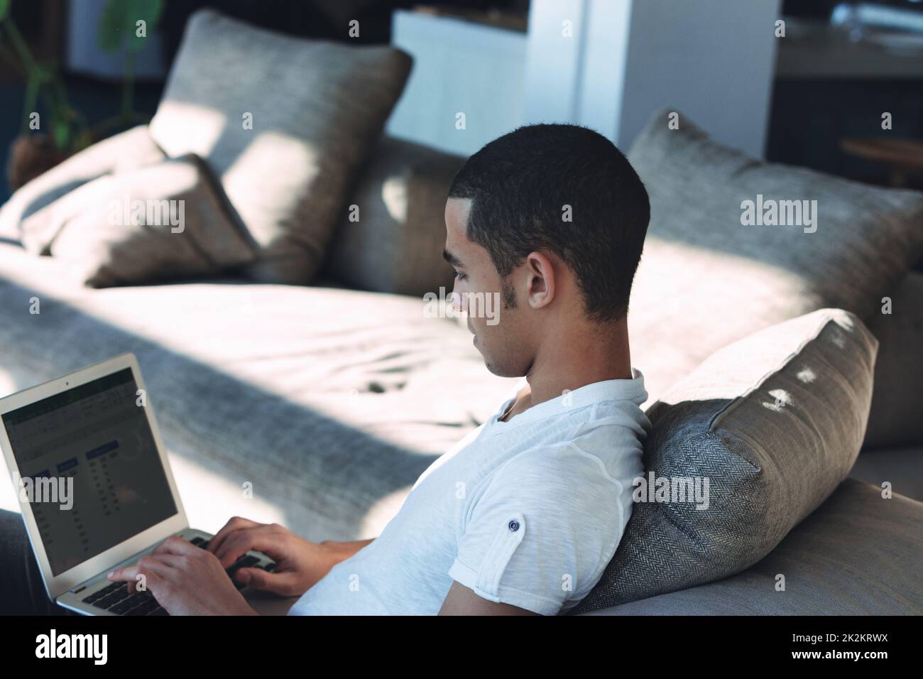 Young Black man telecommuting or working from home on a laptop Stock Photo