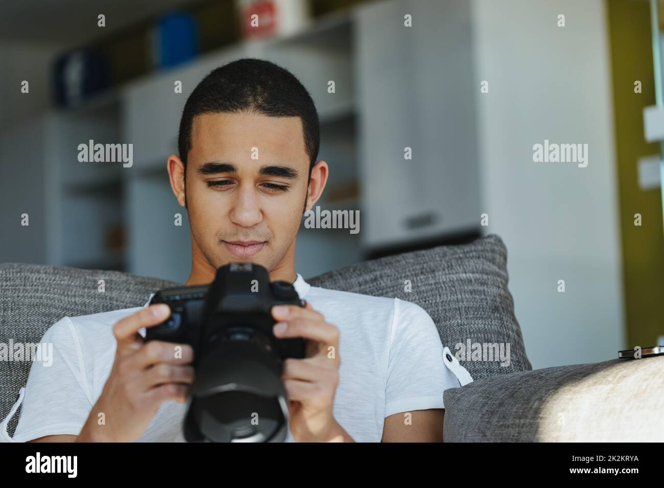 Black male photographer chimping his shot in the viewfinder Stock Photo