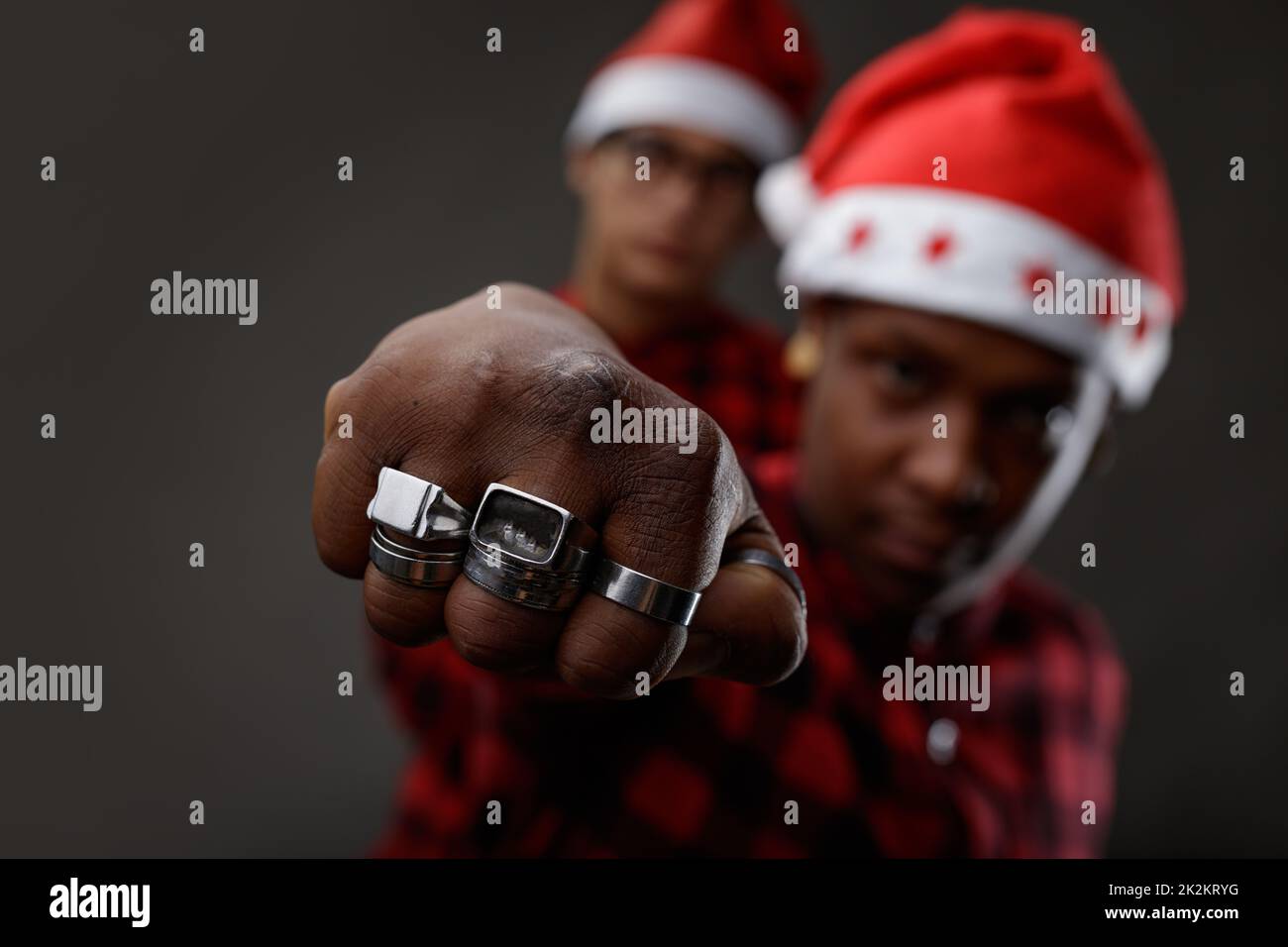 Young Black man wearing a Santa Claus hat and rings Stock Photo