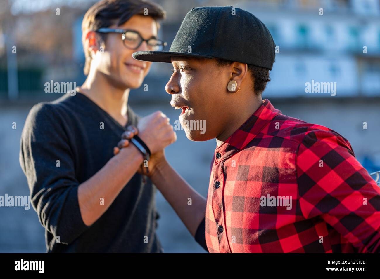 Two happy young men greeting each other in the street Stock Photo