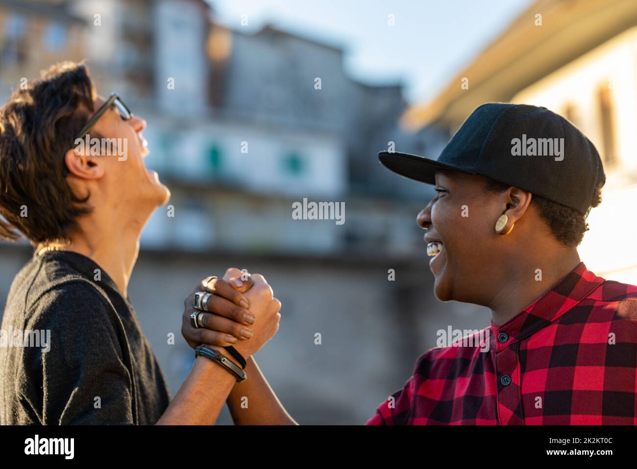Two young men sharing a good joke laughing together Stock Photo