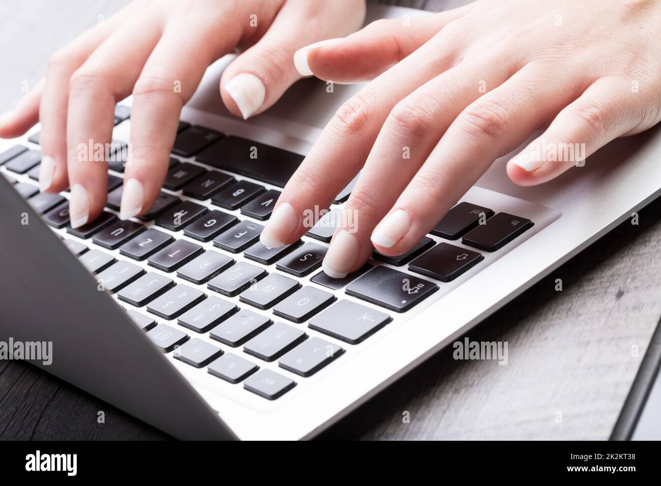 Young woman entering data on a laptop computer Stock Photo