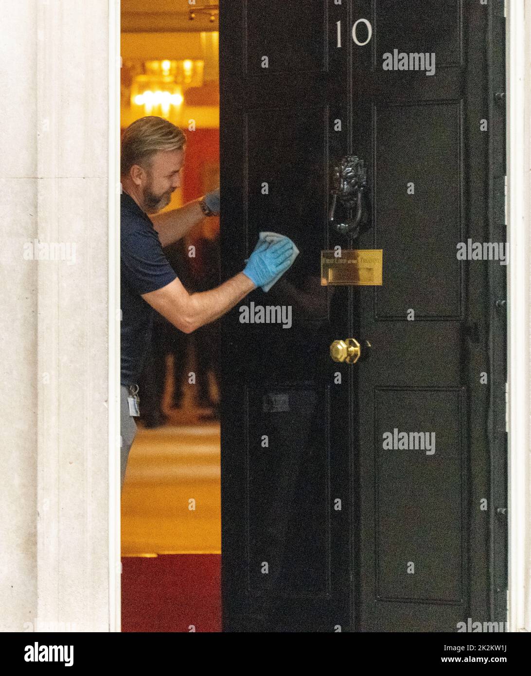 London, UK. 23rd Sep, 2022. man cleans the front door of 10 Downing Street London. Credit: Ian Davidson/Alamy Live News Stock Photo