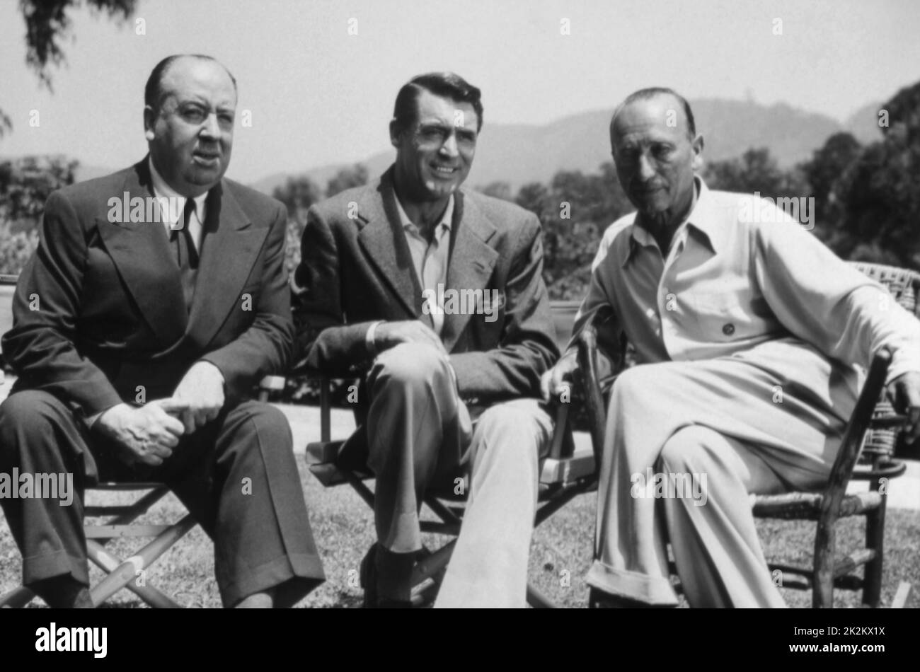 Michael Curtiz, Cary Grant, Alfred Hitchcock On the set of  Night and Day 1946 USA Stock Photo
