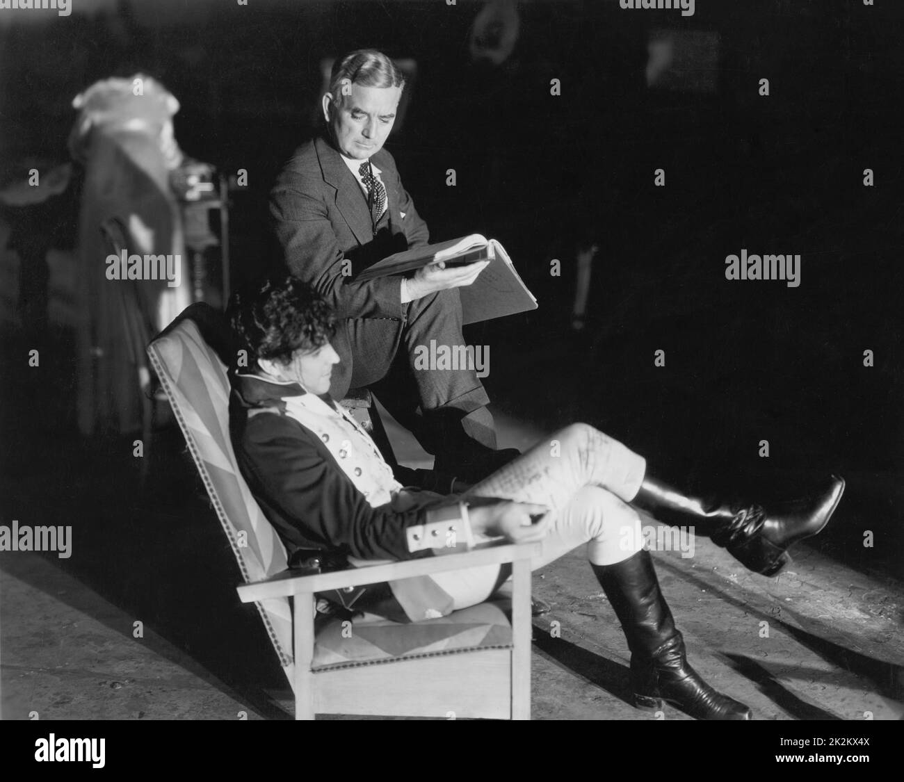 Clifford Brooke, famous stage director, acts as a prompter while Ramon Novarro works with the lines of his first talking picture. Devil-May-Care USA, 1929 Stock Photo