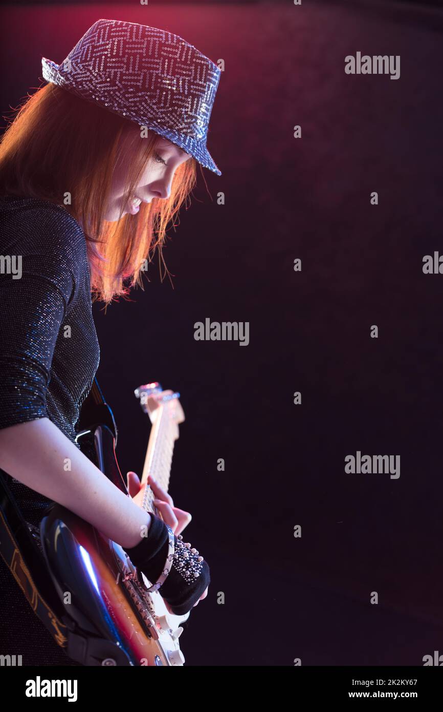 showgirl intensely playing her guitar live Stock Photo