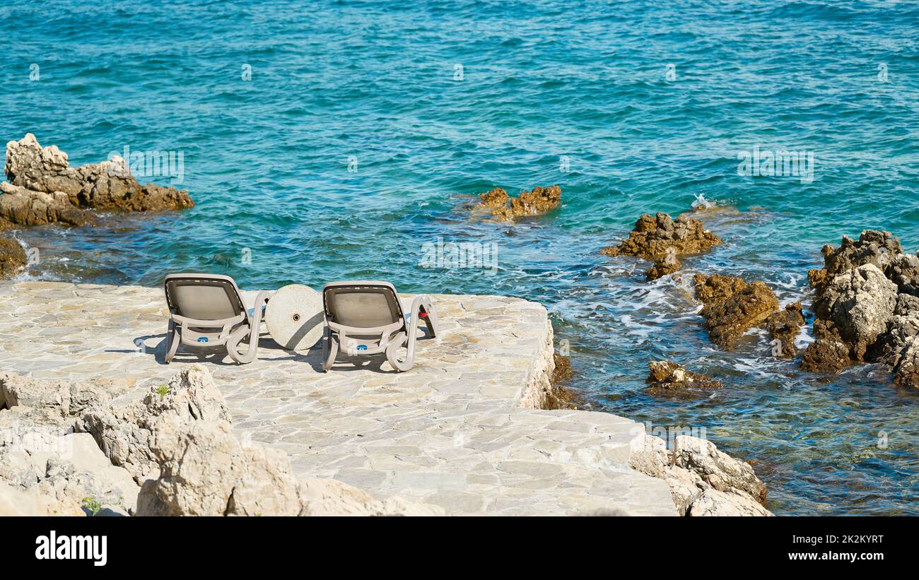 two sunbeds at a bathing place on the rocky coast of the Adriatic Sea near Krk in Croatia Stock Photo