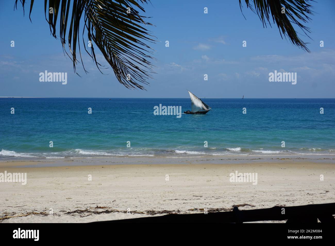 View onto the beach and a Dhow in the water from a cafe in Stone Town, Zanzibar Stock Photo