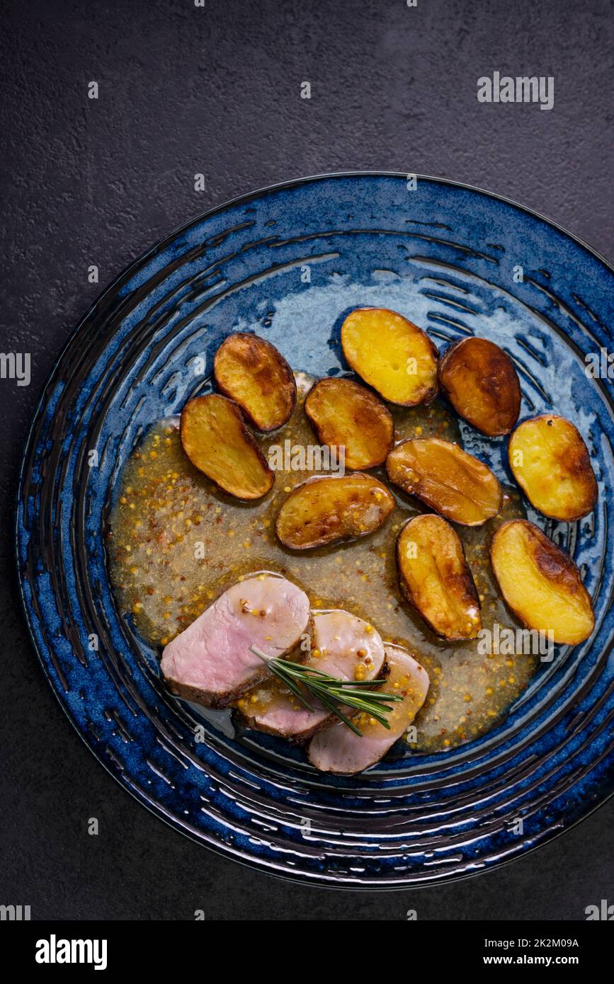 pork tenderloin with baked potatoes and French coarse mustard sauce