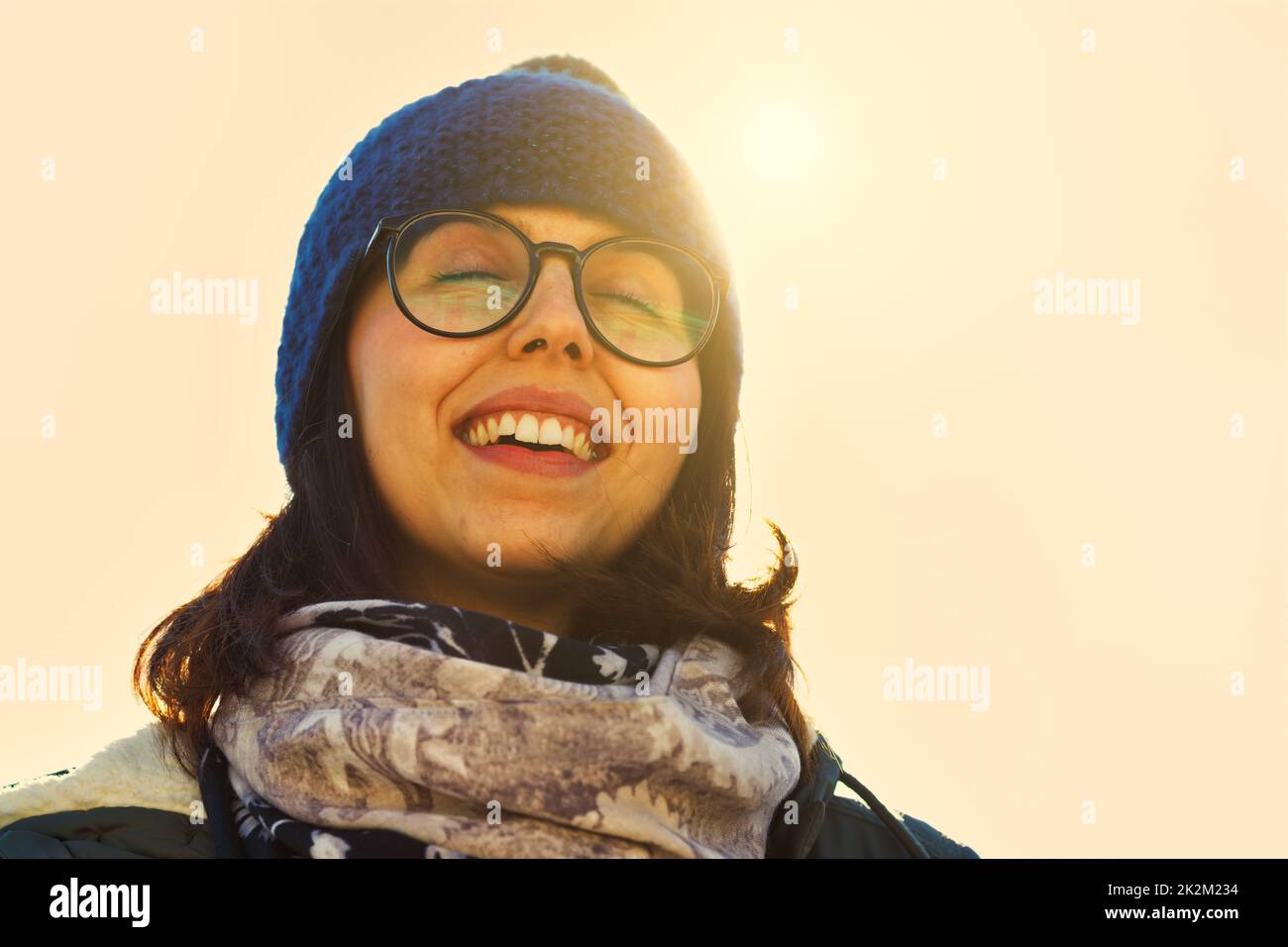Warm light image of a happy laughing woman in a beanie Stock Photo