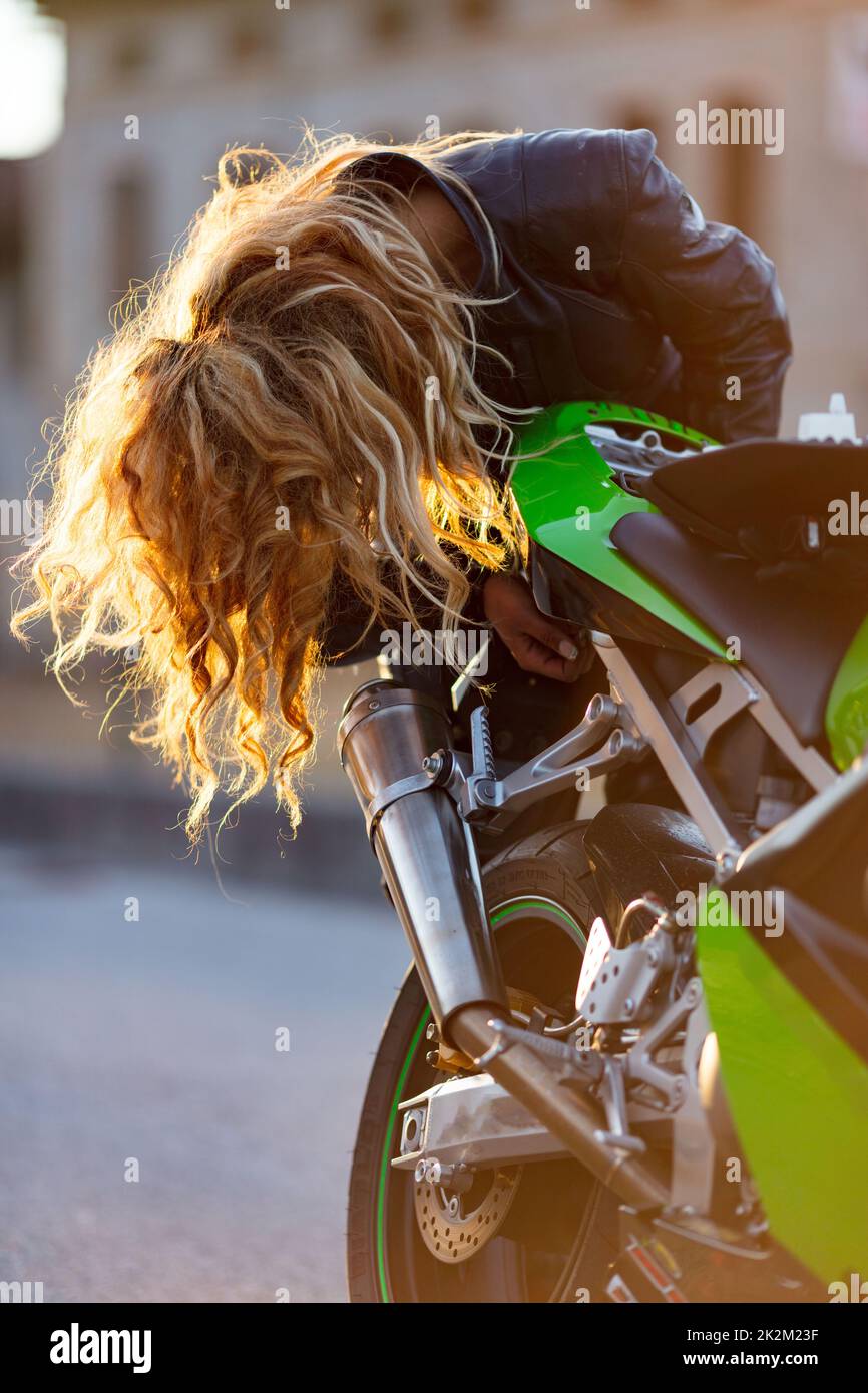 woman setting up her motorcycle to run Stock Photo