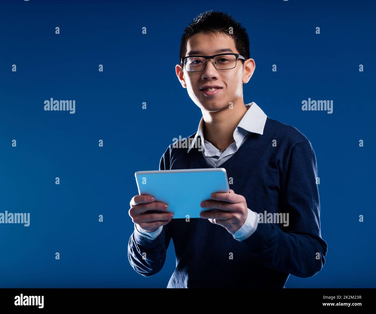 chinese guy smiling holding an ipad Stock Photo