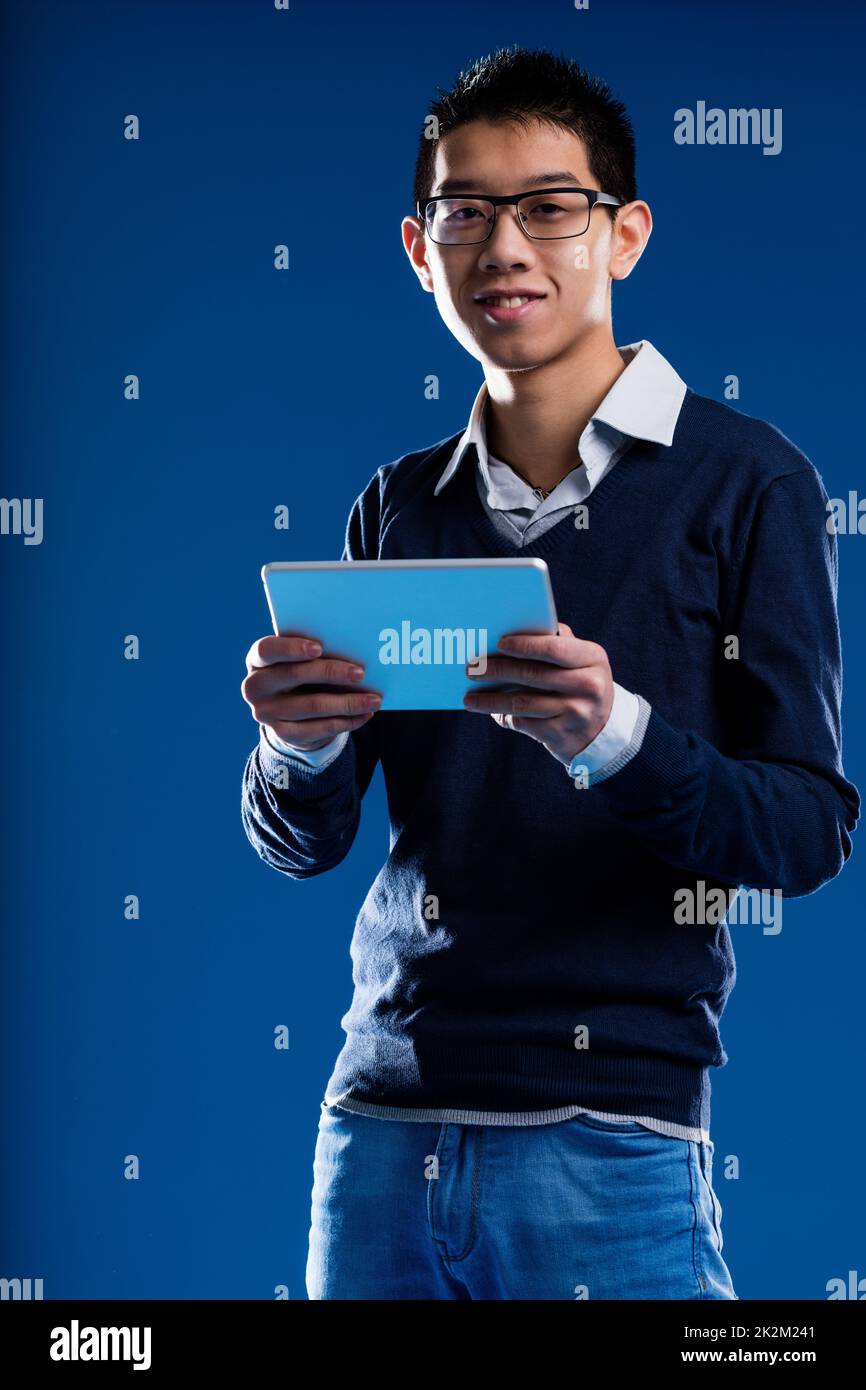 chinese guy smiling holding an ipad Stock Photo