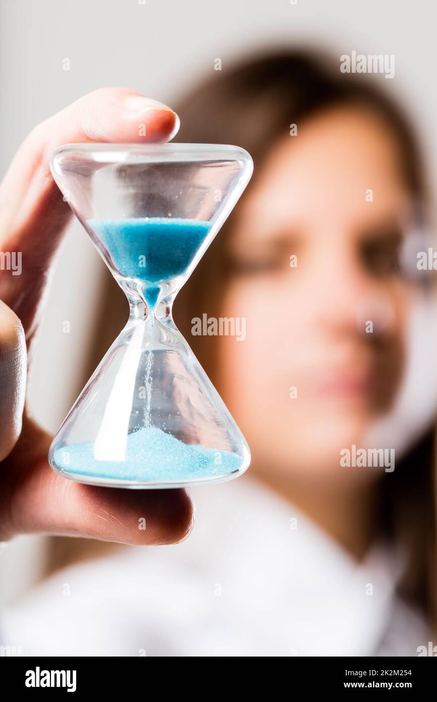 hourglass held by a concerned woman Stock Photo