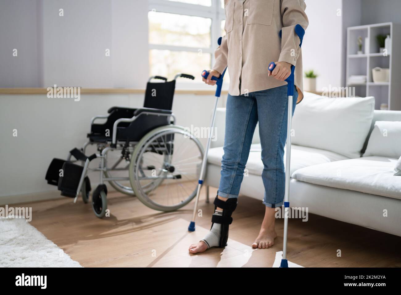 Hurt Leg Using Crutches Near Wheelchair Stock Photo Alamy