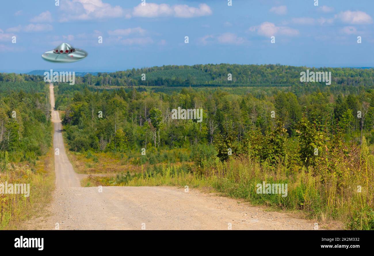 Flying saucer hovering over a dirt road in remote Maine Stock Photo