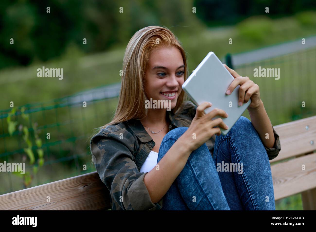 Young blond teenager staring at her tablet in astonishment Stock Photo