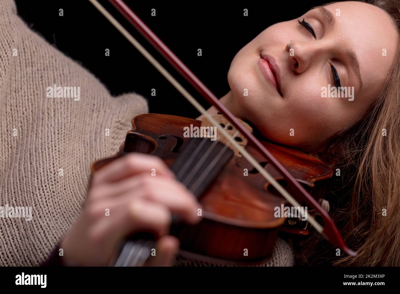 woman playing violin with her eyes closed Stock Photo