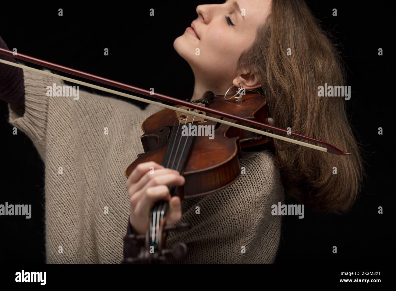 Passionate female violinist playing baroque guitar Stock Photo