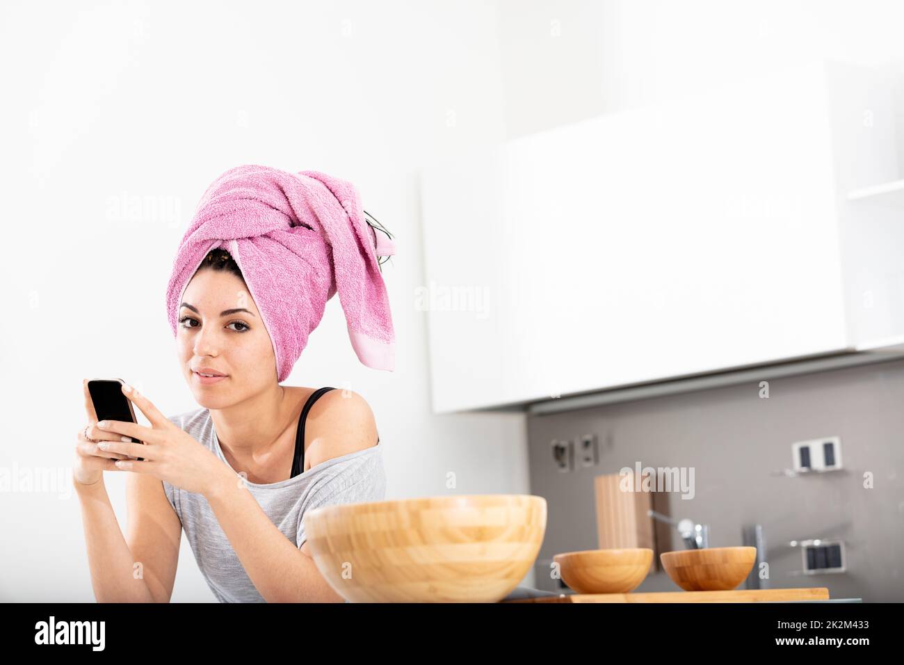 Young woman with her hair tied up in a pink towel Stock Photo