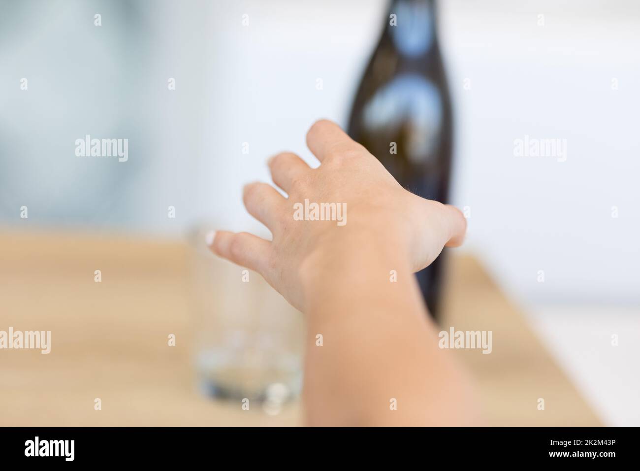 Female hand reaching after bottle Stock Photo