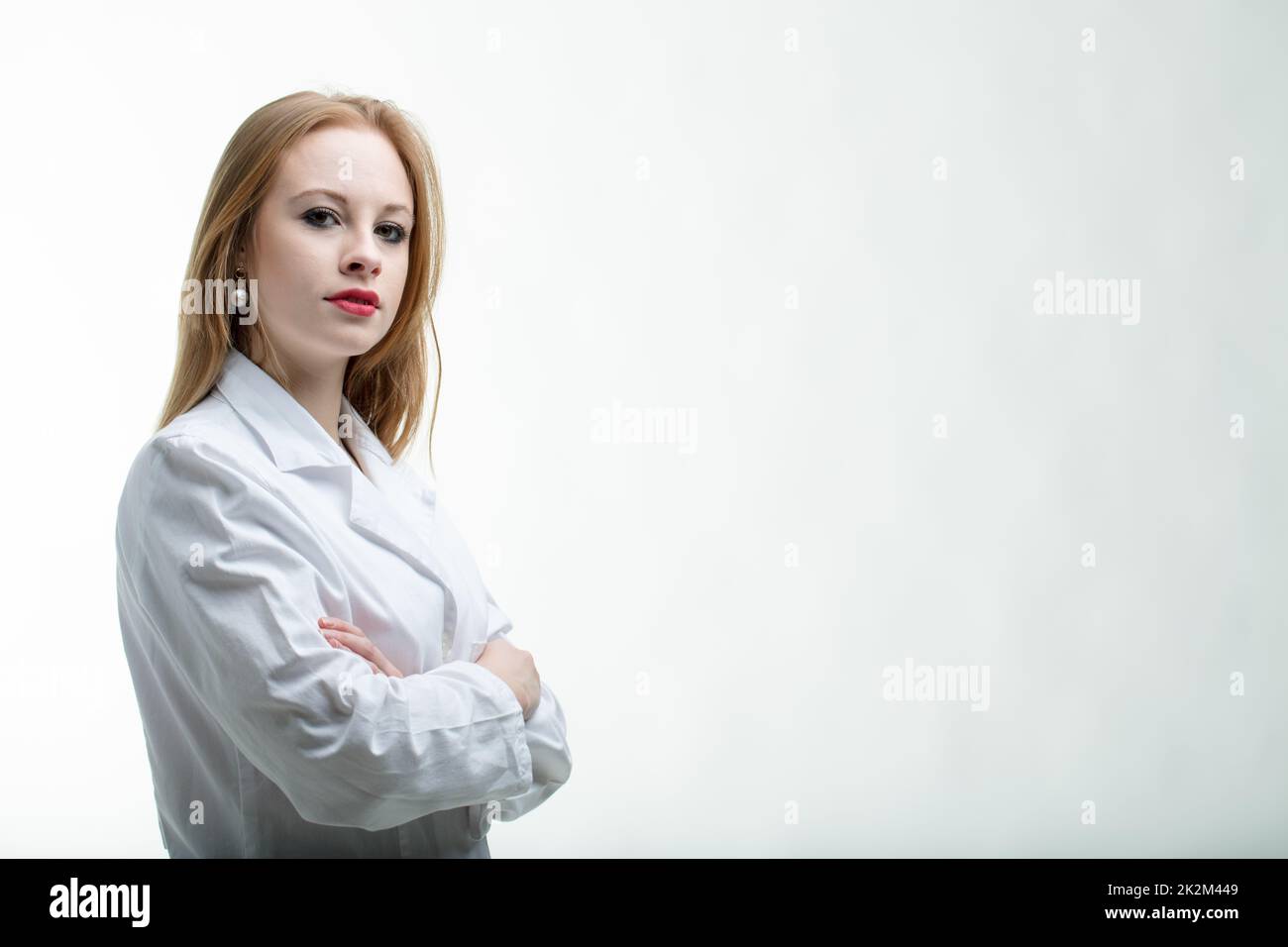 Thoughtful young female doctor with folded arms Stock Photo