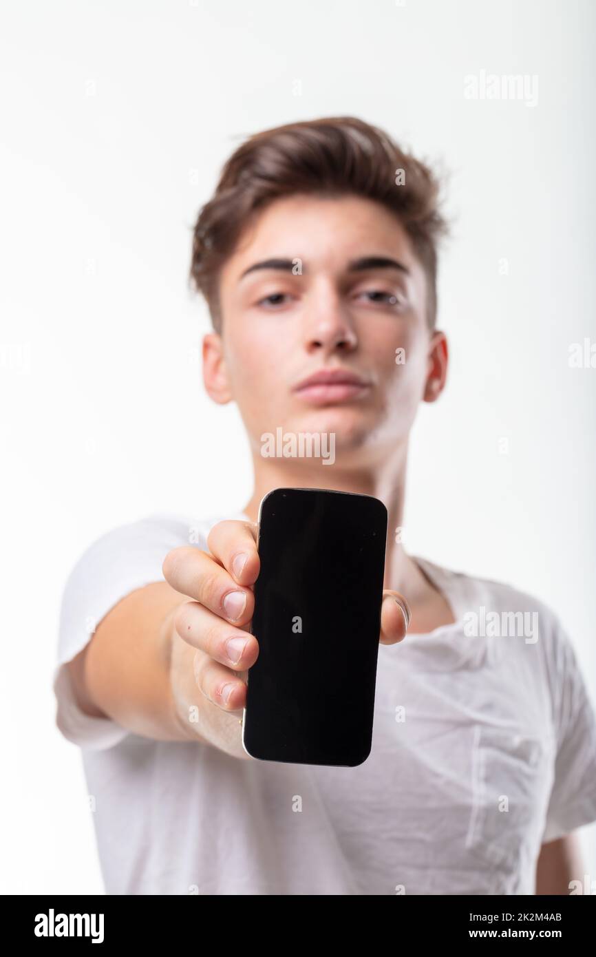 Young man holding a blank mobile phone towards the camera Stock Photo