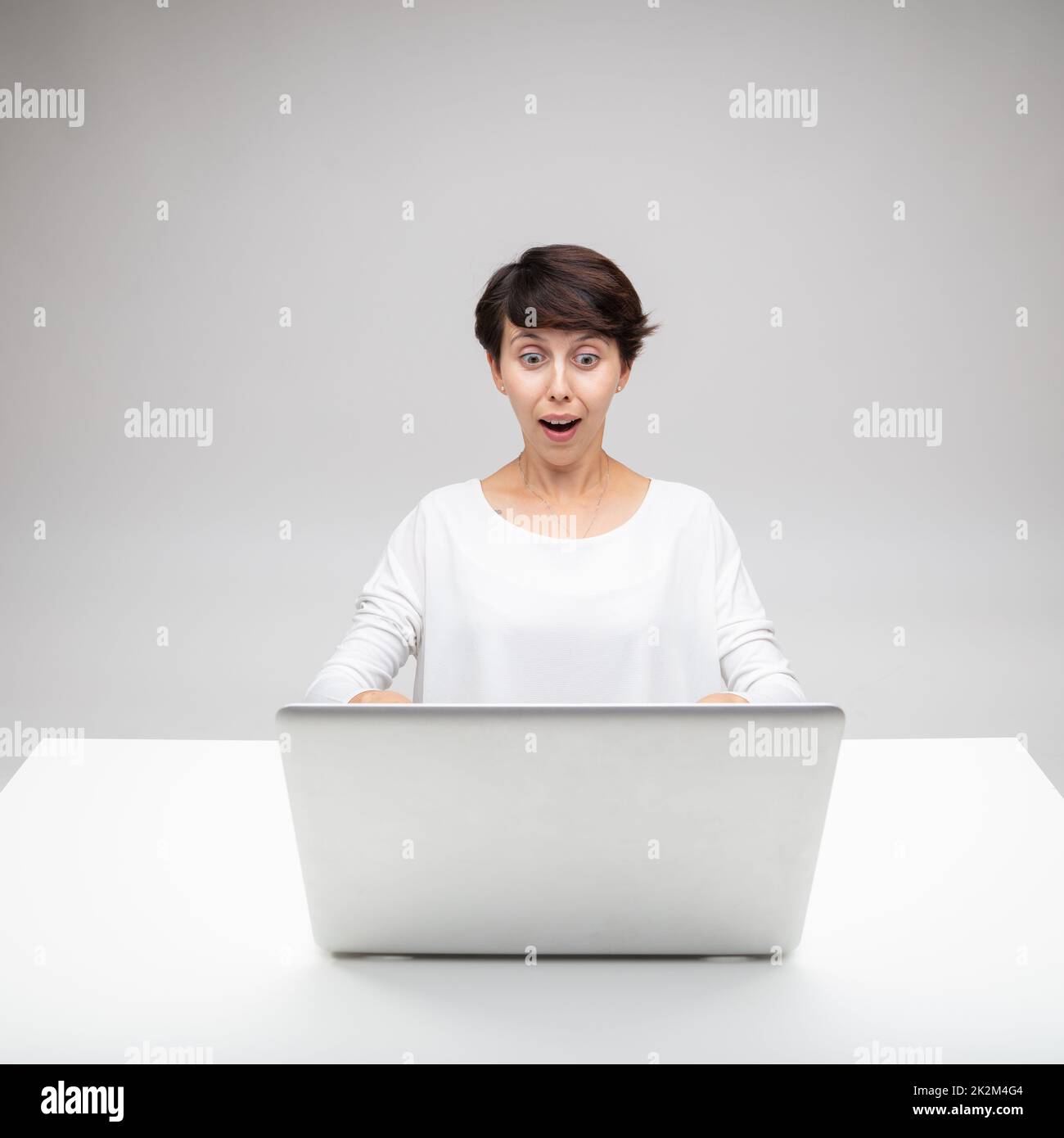 Astonished woman gawping at a laptop Stock Photo