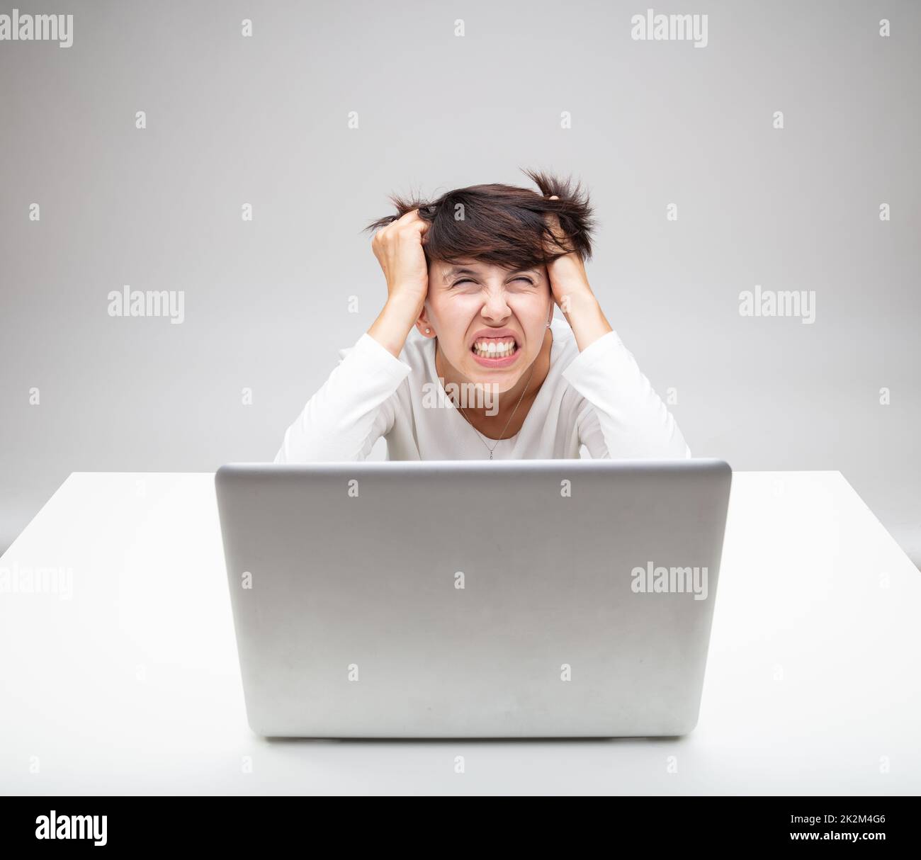 Frustrated businesswoman tearing at her hair Stock Photo