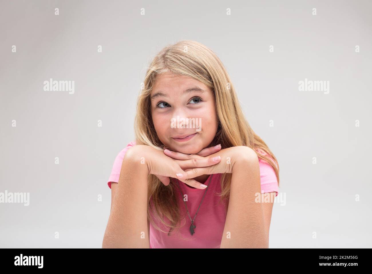 baby girl having an idea in pink on white background Stock Photo