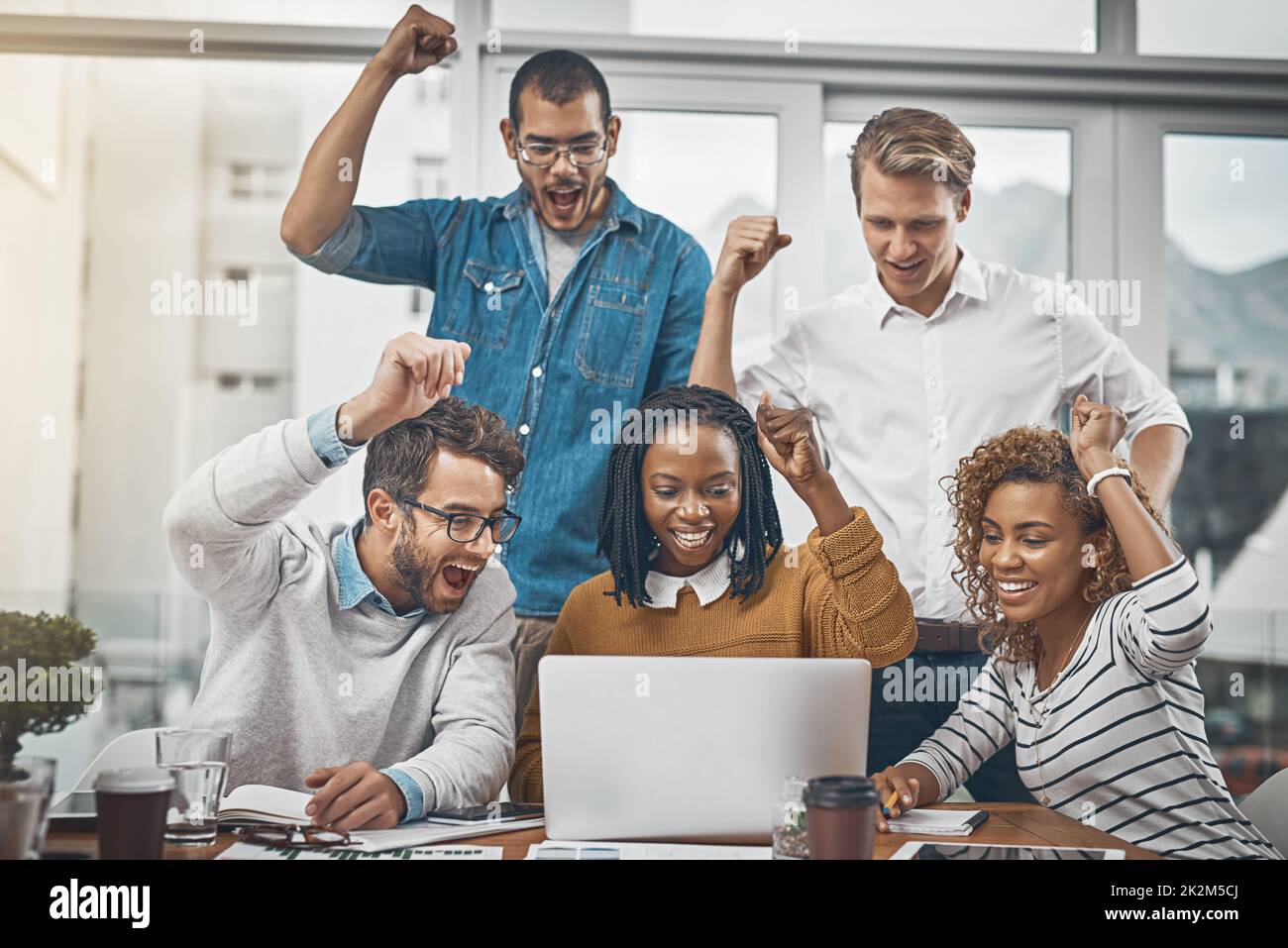 The numbers are in and they look good. Shot of colleagues cheering at something on a laptop screen. Stock Photo