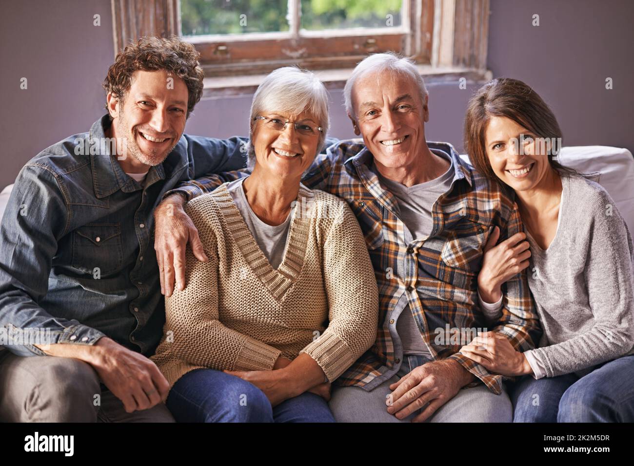 At the in-laws. A portrait of happy mature parents sitting with their adult children at home. Stock Photo