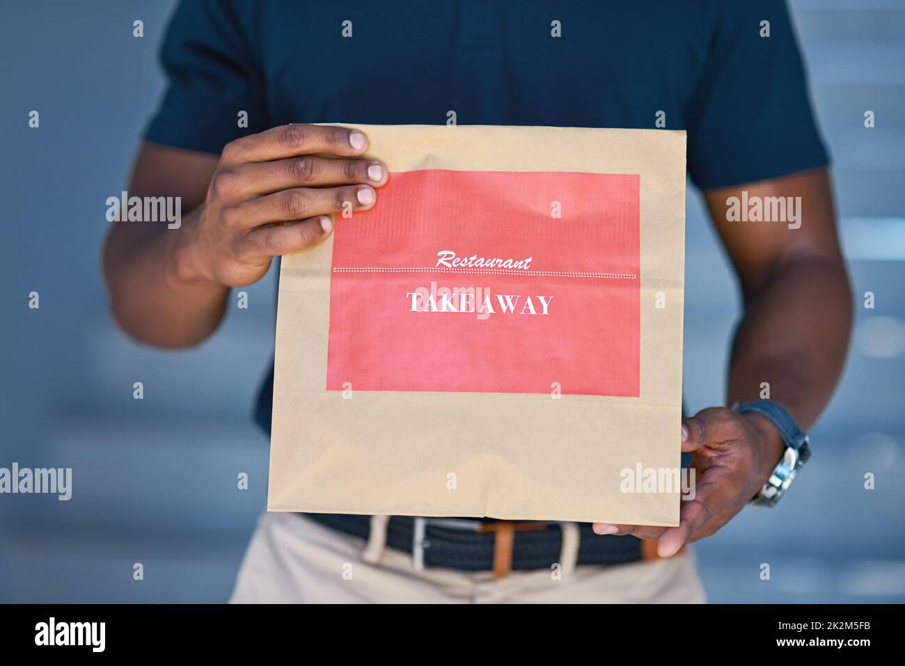 Delivered fresh and fast. Cropped shot of an unidentifiable delivery man holding a restaurant takeaway. Stock Photo