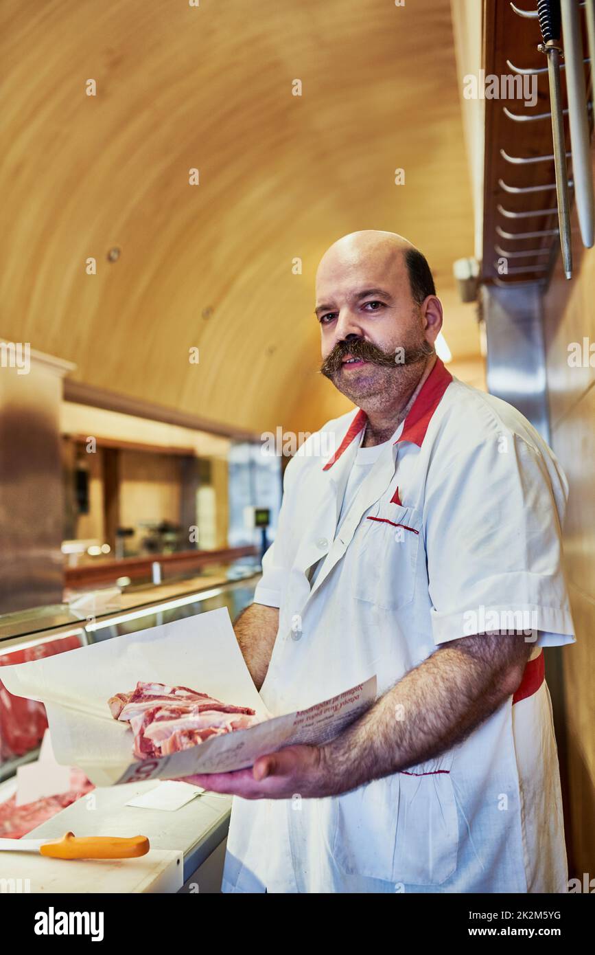 Im in the business to give you quality. Shot of a butcher at his store. Stock Photo