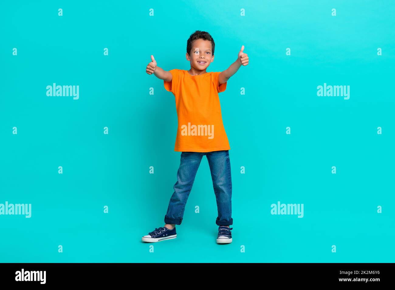 Photo of satisfied boy learner raise two arm show approval yes symbol enjoy nice lesson empty space isolated on cyan color background Stock Photo