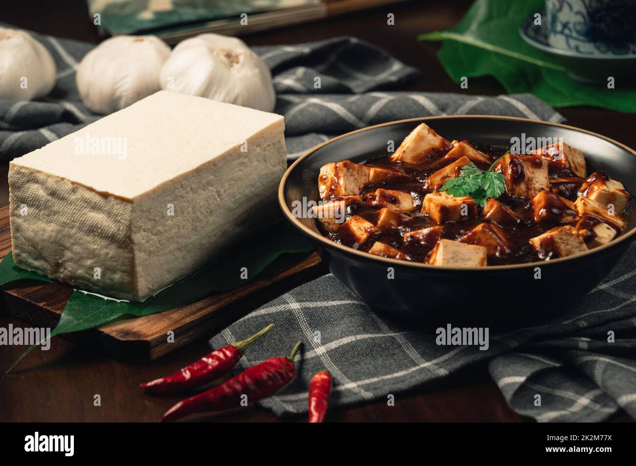 Traditional spicy hot chinese food,Mapo Tofu dressed with tea cup,on wooden plate with dark