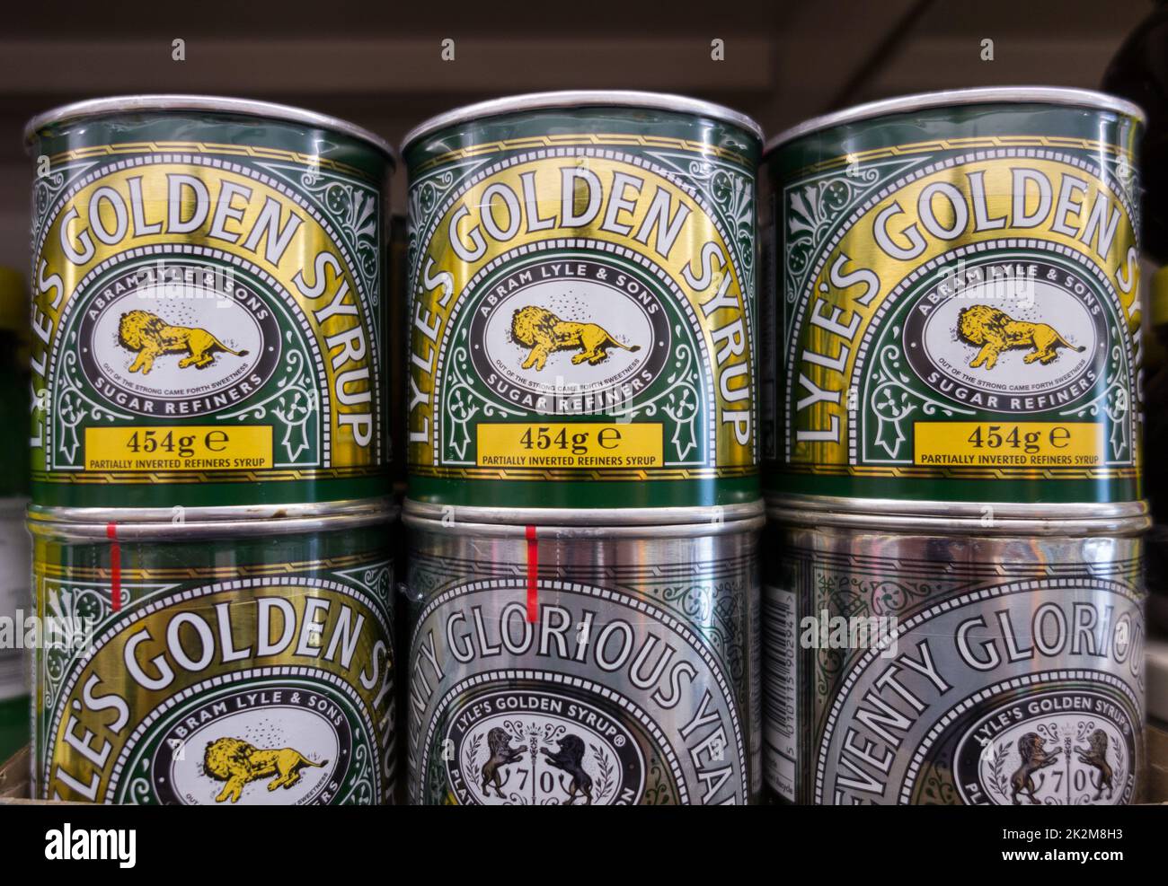 Closeup of Tate and Lyle Golden Syrup tins stacked on a supermarket shelf in London, England, UK Stock Photo