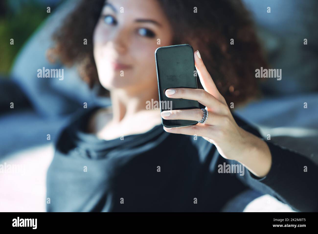 Young woman watching media on her mobile phone Stock Photo