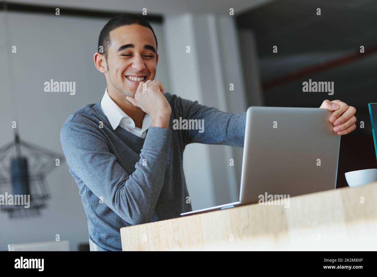 Black man smiling as he works on his laptop or watches media Stock Photo