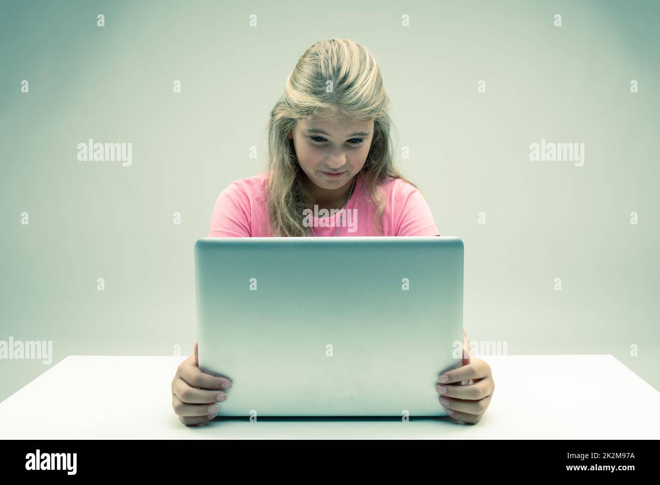 Young girl looking at her laptop with distaste Stock Photo