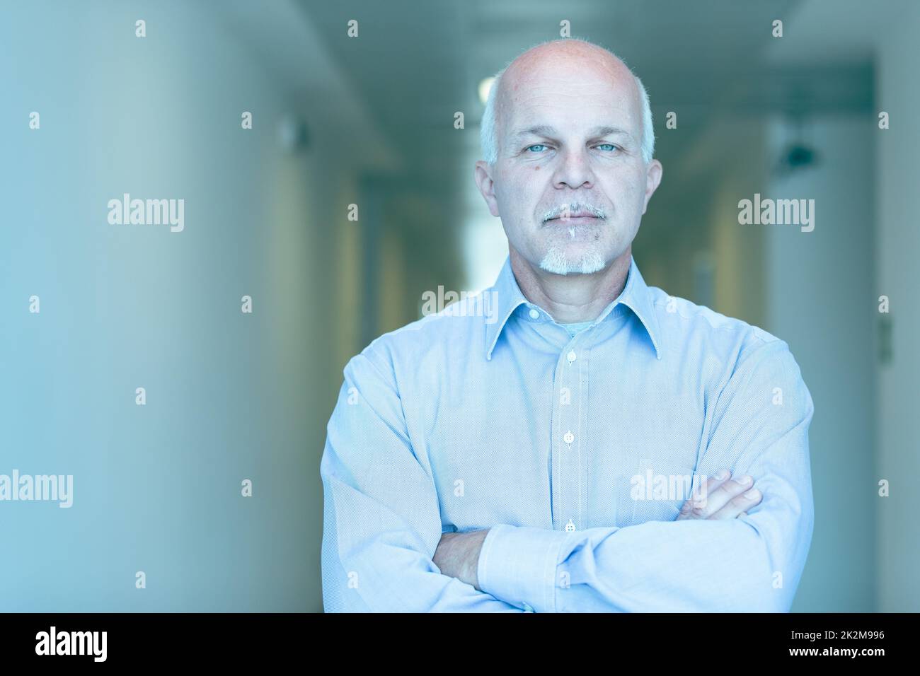 Inscrutable businessman staring at camera with deadpan look Stock Photo