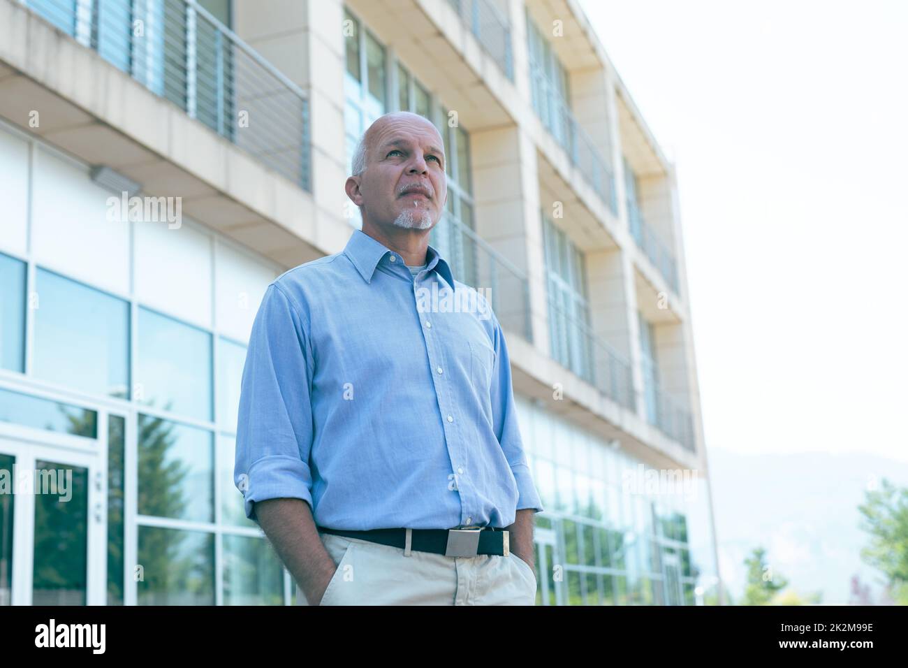 Troubled senior man staring up in angst at the sky Stock Photo