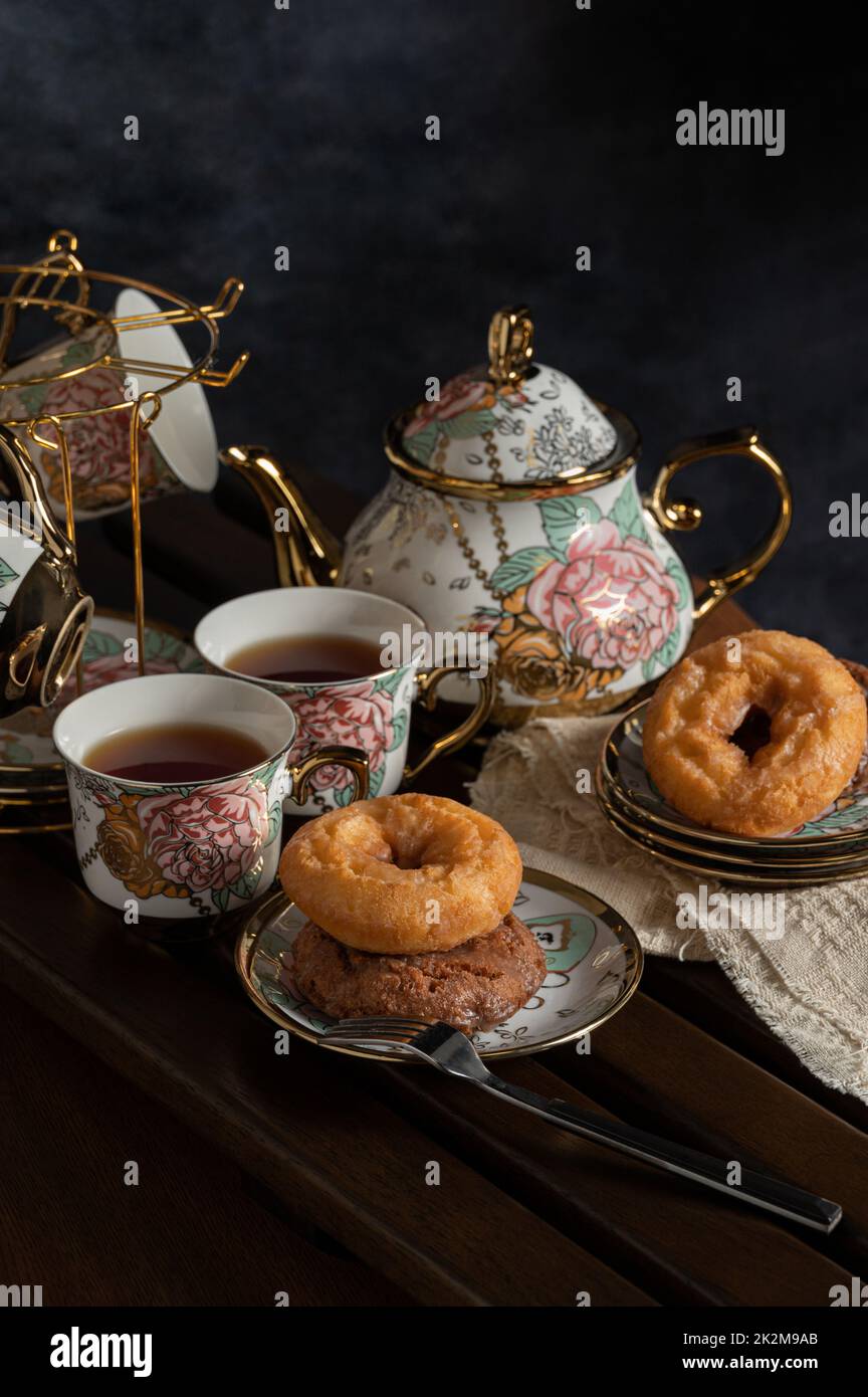 afternoon tea image with black tea,donuts and beautiful teapot and cup