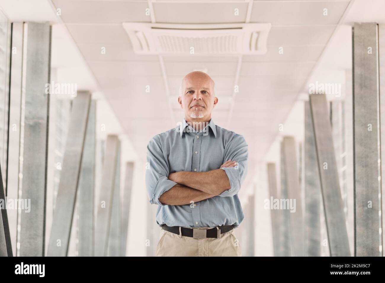 Half-length portrait of a man in the middle of a very modern hallway Stock Photo