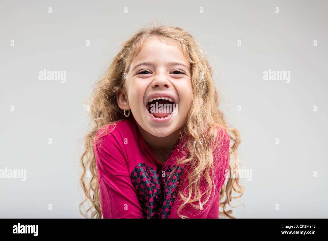 Laughing schoolgirl with curly hair Stock Photo